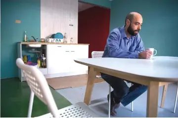  ?? — AFP photos ?? Hector Cabanol, a 36-year-old electricia­n, drinks coffee in the kitchen of a capsule flat of a “beehive”-style housing project in Barcelona.