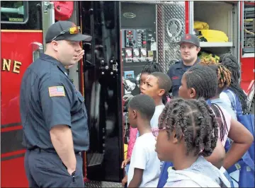  ??  ?? ABOVE: Rome-Floyd Fire Department Sgt. Chris Moreland (left) and firefighte­r Hilton Hamilton show off the features of a rescue truck in the parking lot across from Lovejoy Baptist Church during the Summer Explosion Camp.LEFT: Floyd Medical Center paremedic Lt. Ben Harbin stands outside an ambulance while Desmond Davis Jr., 8, who goes to school in Tuscaloosa, Alabama, climbs out.BELOW: Rome-Floyd County Commission on Children and Youth Executive Director Carol Willis talks with Jataya Barnett (from left), 16, Jakeria Harris, 14, and Jasli Montgomery, 16.