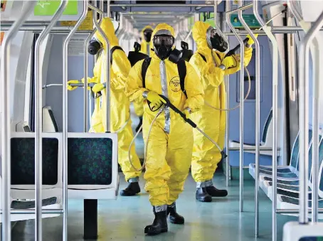  ?? AFP ?? Brazilian soldiers disinfect a train carriage as a measure against the spread of the coronaviru­s pandemic in Rio de Janeiro.