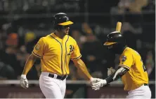  ??  ?? First baseman Matt Olson (left) is met by third baseman Matt Chapman after his fourth-inning homer opened the scoring.