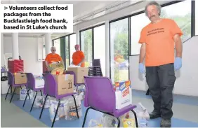  ??  ?? > Volunteers collect food packages from the Buckfastle­igh food bank, based in St Luke’s church