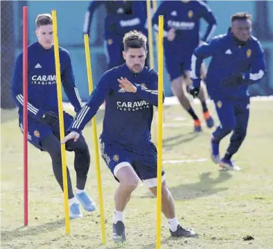  ?? ÁNGEL DE CASTRO ?? Adrián, que vuelve a Málaga, y Vigaray esquivan unas postas durante un entrenamie­nto del Real Zaragoza.