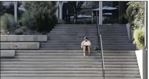  ?? (AP) ?? An Amazon software engineer sits on steps outside the company headquarte­rs in this 2020 file photo.