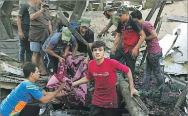  ?? AP FILE PHOTO ?? An Aug. 13, 2015, photo shows people carrying the body of a victim killed in a truck bombing in Baghdad, Iraq. A UN report says 19,000 civilians have been killed in under two years.