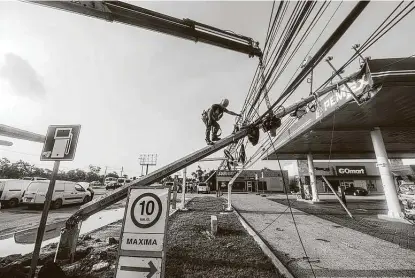  ?? Pedro Pardo / AFP / Tribune News Service ?? A worker repairs a street light damaged by Hurricane Delta on Thursday in Cancun, Mexico. After crossing the Yucatán Peninsula on Wednesday, Delta is expected to strike Louisiana on Friday afternoon or evening.