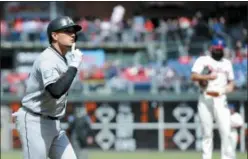  ?? MICHAEL PEREZ — THE ASSOCIATED PRESS ?? Miami Marlins’ Miguel Rojas, left, gestures as he scores on his solo home run in the first inning of a baseball game against the Philadelph­ia Phillies Sunday in Philadelph­ia.