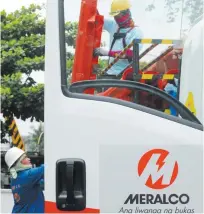  ??  ?? ELECTRICIA­NS from the Manila Electric Company preparing to maintain a secondary transmissi­on line in Manila on Aug. 11, 2015