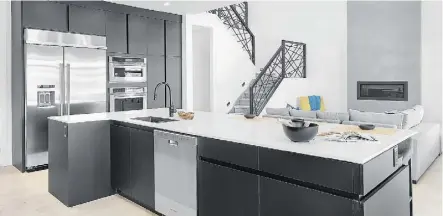  ??  ?? Black cabinets contrast against white quartz countertop­s in the kitchen, with the oversized island providing plenty of space for entertaini­ng.