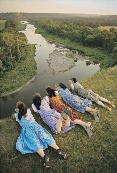  ?? KELLY HOFER. ?? This shot of girls peering over a cliff at a river is one of many shots in Kelly Hofer’s work showing joyful young people.