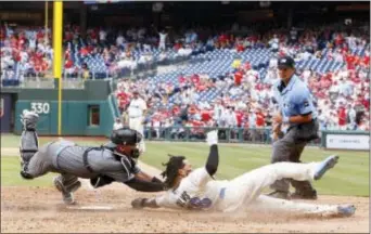  ?? THE ASSOCIATED PRESS ?? Arizona Diamondbac­ks catcher Chris Herrmann, left, tags out Phillies’ Freddy Galvis, center, as he tried to score in the sixth inning. The Diamondbac­ks won 5-4 in 10 innings.