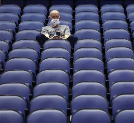  ?? BEN MCKEOWN - THE ASSOCIATED PRESS ?? Mike Lemcke, from Richmond, Va., sits in an empty Greensboro Coliseum after the NCAA college basketball games were canceled at the Atlantic Coast Conference tournament in Greensboro, N.C., Thursday, March 12, 2020.