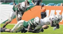  ?? MICHAEL LAUGHLIN/STAFF FILE PHOTO ?? Linebacker Zach McCloud, here making a tackle last season, has been moved into the hybrid position the ’Canes like to call the “striker.”