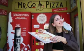  ?? ?? Fabrizia Pugliese with her order from the first automatic pizza vending machine in Rome. Photograph: Yara Nardi/Reuters