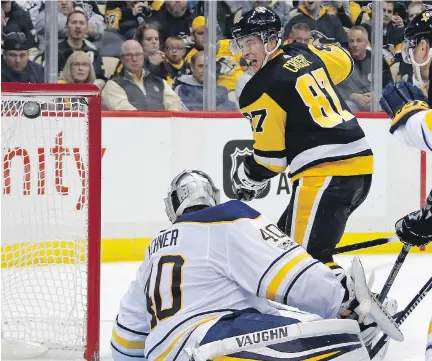  ?? GENE J. PUSKAR/THE ASSOCIATED PRESS ?? Pittsburgh Penguins centre Sidney Crosby lifts the puck over Buffalo Sabres goaltender Robin Lehner for a goal in the second period of Tuesday’s game in Pittsburgh. The goal ended an 11-game stretch in which the 30-year-old could not find the back of...