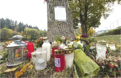  ??  ?? FREIBURG: Flowers and candles sit in front of a tree close to the Dreisam river in Freiburg, Germany, where the body of a student was found. A 17year-old Afghan migrant, who entered Germany last year as an unaccompan­ied minor, has been arrested in...