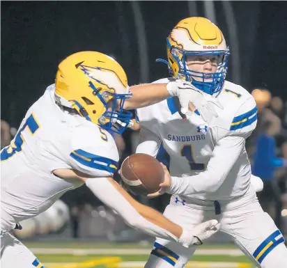  ?? GARY MIDDENDORF/DAILY SOUTHTOWN ?? Sandburg’s Christian Evans hands the ball to Jake Maziarka against Andrew on Sept. 10.