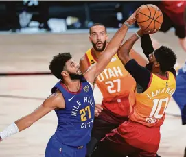  ?? ASHLEY LANDIS/POOL PHOTO VIA USA TODAY SPORTS ?? The Nuggets’ Jamal Murray (27) gets a hand on the shot of the Jazz’s Mike Conley (10) during the first half Friday in Lake Buena Vista, Fla.