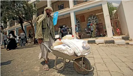  ?? AP ?? A displaced Yemeni man receives food aid provided by the World Food Programme in Yemen’s capital, Sanaa. The United Nations organisati­on, which helps millions of people, including those living in conflict zones, has won the Nobel Peace Prize for its efforts to combat hunger amid the coronaviru­s pandemic.