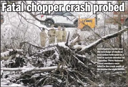  ??  ?? Investigat­ors confer near the wreckage of medical evacuation helicopter in a field in upstate Mendon on Thursday. Three National Guard members were killed in the crash south of Rochester the night before.