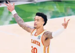  ?? CURTIS COMPTON/ATLANTA JOURNAL-CONSTITUTI­ON ?? Hawks’ John Collins reacts as Trae Young hits a 3-pointer in Game 1 of the Eastern Conference Finals on Wednesday in Milwaukee.