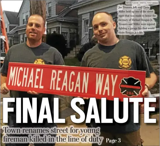  ?? KEVIN TUSTIN – DIGITAL FIRST MEDIA ?? Joe Tesauro, left, and Chris Miller hold up one of the street signs that was made to honor the memory of Michael Reagan Jr.. Tesauro and Miller were injured fighting a garage fire that would claim Reagan Jr.’s life.