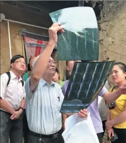  ?? HUO YAN / CHINA DAILY ?? Above: Leung Ping-chung, founder of the charity Operation Concern, examines an X-ray in Fuping, Shaanxi province. Right: Leung oversees a villager’s rehab. LI LEI/ CHINA DAILY