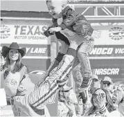  ?? Bob Booth / TNS ?? Kyle Busch (18) plays with his son Brexton as wife Samantha offers support after he won the O'Reilly Auto Parts 500 at Texas Motor Speedway Sunday.