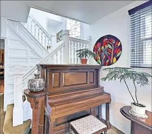  ??  ?? The home features a paneled-wall staircase and a custom stained-glass window.