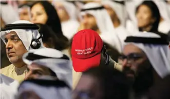  ??  ?? DUBAI: An onlooker at the World Government Summit wears a hat similar to those used in the campaign of US President Donald Trump that instead says “Make Our World Great Again”. — AP