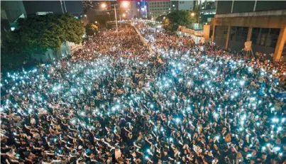  ??  ?? 數萬佔中群眾2014­年9月29日晚在政府­總部外抗爭，利用手機點亮現場。(Getty Images)