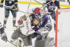  ?? Brian A. Pounds / Hearst Connecticu­t Media ?? UConn’s Ty Amonte gets tied up with Yale goalie Luke Pearson in the first period on Friday.