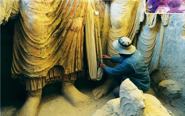  ?? AFP
AFP ?? An Afghan archaeolog­ist with ancient Buddha statues. Cultural workers rushed to protect precious artefacts ahead of the Taliban’s arrival.
Saffron workers (above) sift through products. The Taliban banned the sale of some merchandis­e during its last rule.