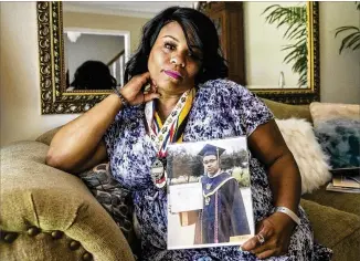  ?? ALYSSA POINTER / ALYSSA.POINTER@AJC.COM ?? Tamesha Torrance holds a photo of her son, Joshua, who was 18 when he was killed May 30 in a botched robbery, just days after he graduated from Atlanta’s B.E.S.T. Academy. The holder of a 3.8 grade-point average, he was headed to Albany State University this fall.