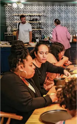  ?? ?? Right: Community manager Darian Gemora (center) speaks to a table of Groundfloo­r members during a Day of the Dead lunch early this month at the co-working space in San Francisco.