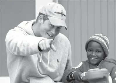  ?? Associated Press photos ?? ■ ABOVE: Britain’s Prince Harry, left, jokes with a child July 9, 2008, during his visit at a newly opened center for abused children in Maseru, Lesotho. ■ LEFT: Britain’s Prince Harry and his fiancee, Meghan Markle, arrive Dec. 25, 2017, to attend the...