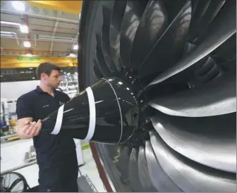  ?? CHRIS RATCLIFFE / BLOOMBERG VIA GETTY IMAGES ?? A technician checks the nose cone of a Trent XWB aircraft engine on the production line at the Rolls-Royce Holdings Plc factory in Derby, the United Kingdom.