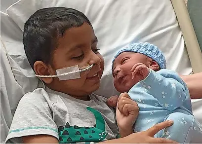  ?? ?? ● Saqib Ashraf holding his new baby brother Arif. Saqib died 13 days after his brother was born; below left and right, with his mum and Aqib, and with mum and dad