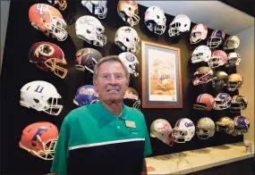  ?? John Raoux / Associated Press ?? Steve Spurrier stands in front of a display of helmets of teams that he previously played for or coached at his new restaurant, the Gridiron Grill in Gainesvill­e, Fla. The restaurant doubles as Spurrier's personal museum.