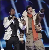  ?? COURTESY OF FOX ?? “The Masked Singer” host Nick Cannon, left, stands with former A’s and Giants pitcher Barry Zito after the latter’s face was revealed. Zito plans a second career in music.