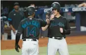  ?? MARTA LAVANDIER/AP ?? The Marlins’ Brian Anderson is congratula­ted by Bryan De La Cruz after scoring during the eighth inning Friday in Miami.