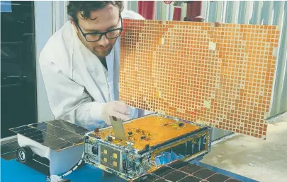  ??  ?? READY TO FLY: Engineer Joel Steinkraus, below, uses sunlight to test the solar arrays on a Mars Cube One (MarCO) spacecraft at NASA’s Jet Propulsion Laboratory in Pasadena, Calif. They’re designed to fly along behind NASA’s InSight lander on its cruise...