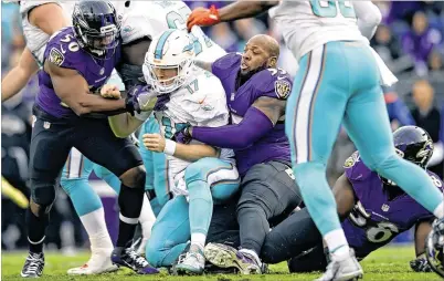  ?? GAIL BURTON / ASSOCIATED PRESS ?? Ravens outside linebacker Terrell Suggs lost his helmet but still put a hit on Dolphins quarterbac­k Ryan Tannehill. The Ravens sacked Tannehill twice and intercepte­d him three times in beating the Dolphins 38-6.