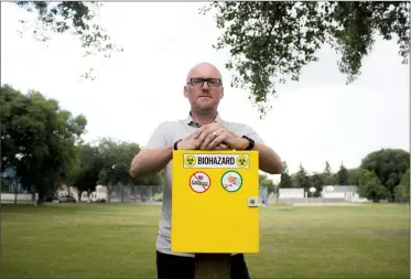  ?? Herald photo by Greg Bobinec ?? Lethbridge City Councillor Blaine Hyggen poses for a photo with a biohazard box for used drug needles at Kinsmen Park, and says that council should direct Arches to stop the distributi­on of needles leaving the Supervised Consumptio­n Site.