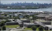  ?? SETH WENIG—ASSOCIATED PRESS ?? This June 20, 2014 file photo shows the Rikers Island jail complex in New York with the Manhattan skyline in the background. More than three dozen people have tested positive for coronaviru­s in New York City jails, including at Rikers Island, the board that oversees the city’s jail system said Saturday, March 21, 2020.