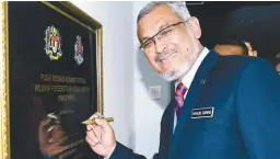  ??  ?? Khalid signing a plaque to mark the opening of the centre.