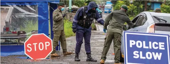  ?? Photo: Leon Lord ?? Police and military personnel guard the entrance to Qauia Settlement in Lami. The settlement remains in lockdown.