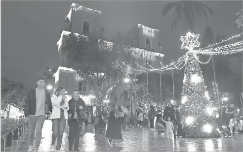  ?? /XCA ?? Turistas visitan el Parque Calderón, que luce la iluminació­n navideña en la Catedral y en los edificios aledaños.