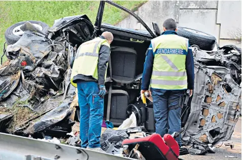  ??  ?? Rescue workers at the scene of the crash later needed counsellin­g. The British family’s car is believed to have gone over a railing before hitting a concrete wall