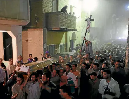  ??  ?? Mourners march at the funeral in Minya of several of the 29 Coptic Christians killed by gunmen while travelling to a monastery in southern Egypt.