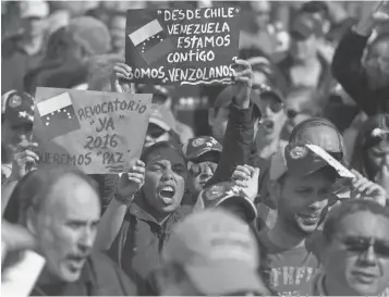  ?? ESTEBAN FELIX, AP ?? Venezuelan­s living in Chile protest the government of Venezuela’s President Nicolas Maduro in the capital, Santiago, earlier this month.